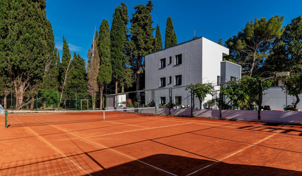 Private fenced tennis court surrounded by pine forest on the property of the luxurious villa Velvet Bourbon Split