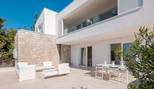 View of the exterior of the luxury villa Primosten Glamour in Primosten and the outdoor terrace with seating and a table