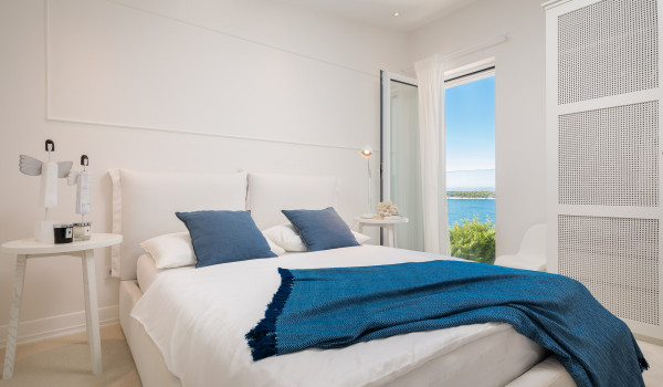 A bedroom of Croatia pool villa for rent with a double bed and sea view in Primosten for family vacation