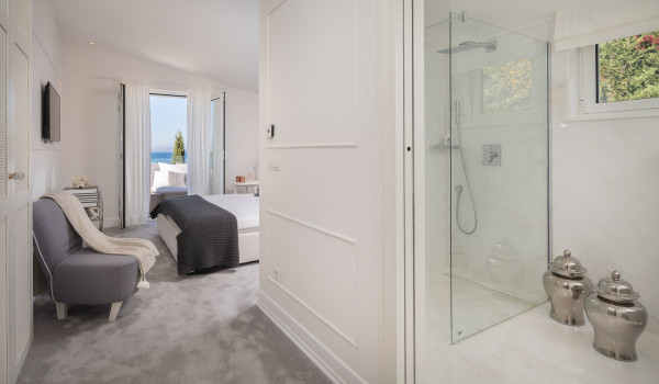 A bedroom of Croatia luxury family villa with an en suite bathroom, a double bed and its own exit to the balcony with sea view