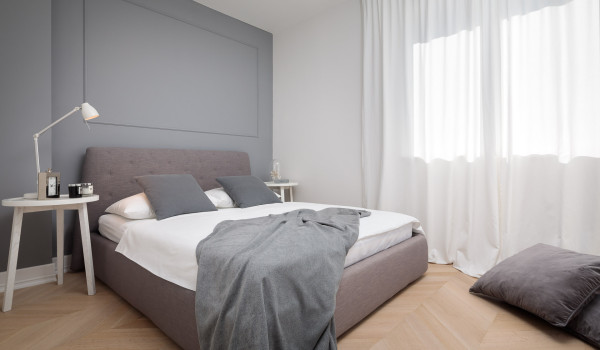 A bedroom decorated in gray with a comfortable double bed in the luxury Croatia modern villa for family vacation in Primosten