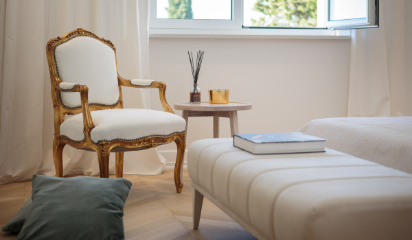 A comfortable armchair next to the double-size bed in the bedroom of Croatia luxury vacation villa