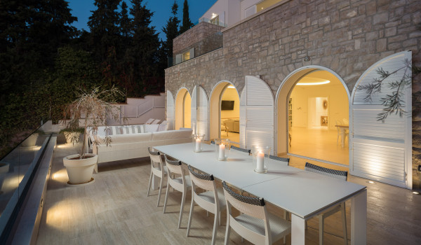 Outdoor terrace of Croatia luxury rental villa with lounge area and dining table with chairs in Primosten