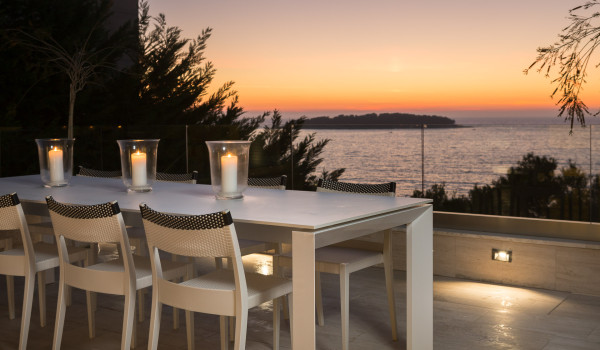 Night view of the outdoor terrace and dining table overlooking the sea in the luxury Croatia villa with private pool for vacation
