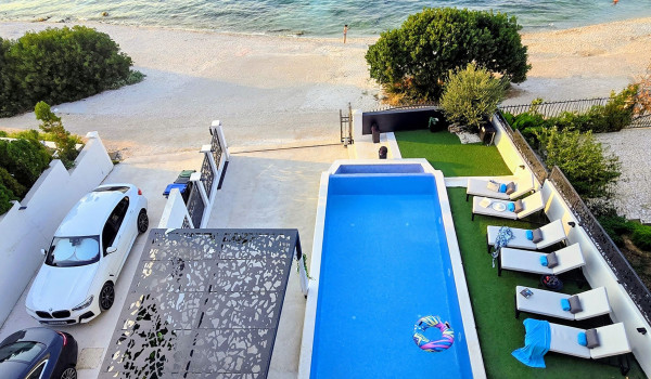 Luxury beachfront villa for rent with 2 pools - deck chairs by the  heated pool