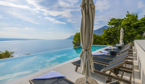 Sunbed with sunbeds next to the private pool on the outdoor terrace with a view of the sea in the luxurious villa Glorious Brela in Brela