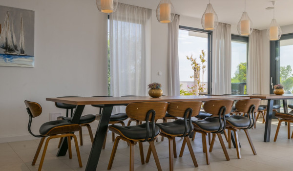 Wooden dining table with chairs in the dining room of the luxury family villa Glorious Brela in Brela