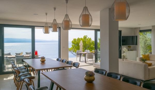 The interior of the luxury villa for rent Glorious Brela in Brela with dining room and living room and access to the outdoor terrace with a view of the sea