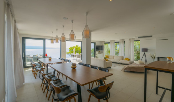 The interior of the luxury villa for rent Glorious Brela in Brela with dining room and living room and access to the outdoor terrace with a sea view