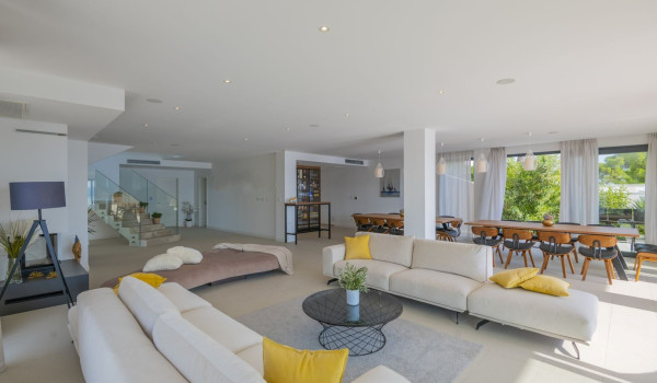 View of the interior of a Croatian luxury villa for rent in Brela with comfortable sofas in the living room and a dining table and chairs.