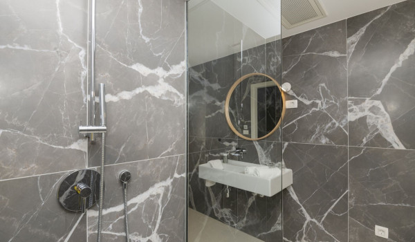 Bathroom with shower, sink and mirror in a modern villa for rent in Brela