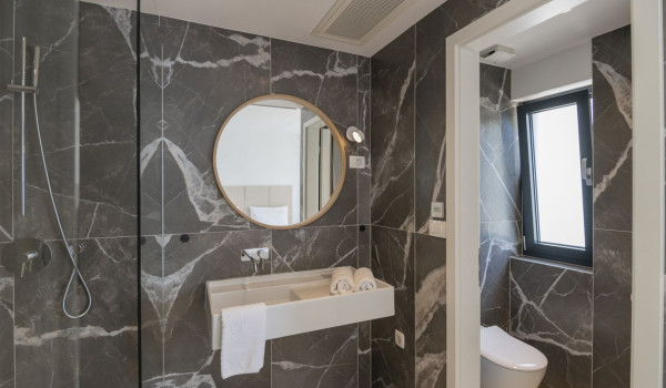Bathroom with toilet, shower cabin, sink and mirror in the luxury holiday villa Glorious Brela in Brela