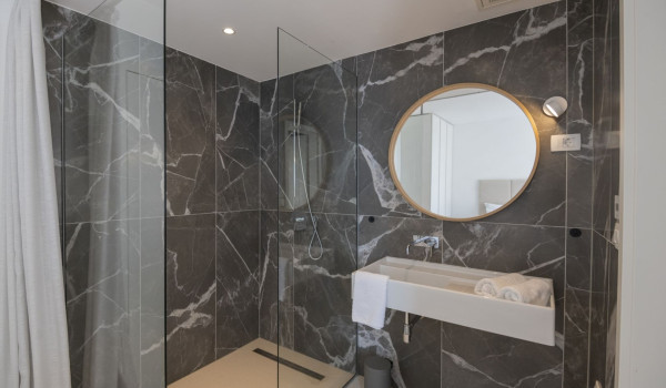 Shower cabin, sink and mirror in a modern bathroom in a luxury holiday villa for rent and vacation in Brela