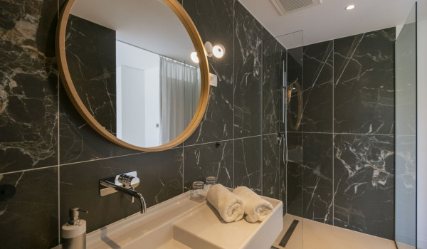 En suite bathroom with shower, sink and mirror in a modern villa for rent in Brela