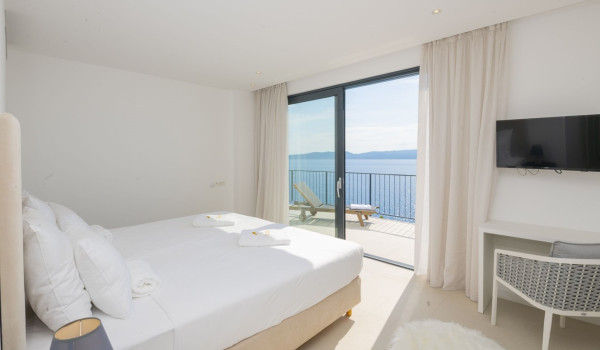 Bedroom with sea view and private balcony, double bed and LCD TV in a luxury holiday villa in Brela