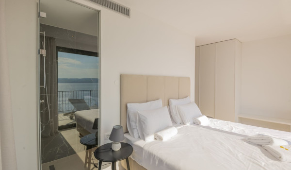 A bedroom with a double bed and a wardrobe in a luxury villa with a private sauna in Brela