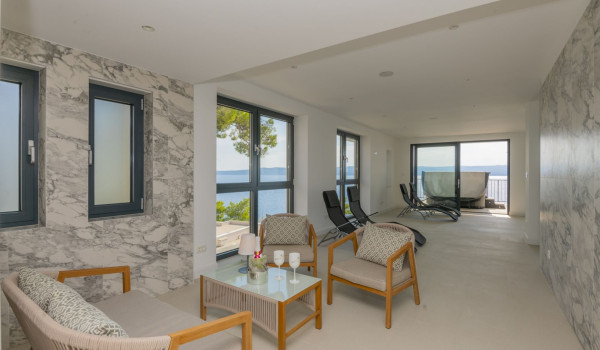 Seating and rest area with wooden table and chairs and deckchairs in the luxury villa for rent Glorious Brela in Brela