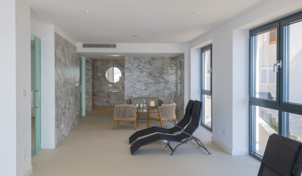 Space for sitting and resting with a table and chairs and deckchairs in a luxury villa with a private gym in Brela