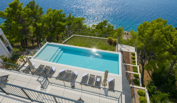 View of the private pool surrounded by deck chairs on the outdoor terrace with a view of the sea in the luxury villa for rent Glorious Brela in Brela