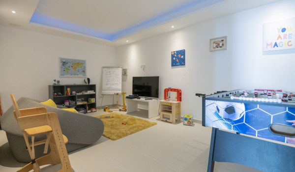 Game and entertainment room with children's toys and table football as well as LCD TV and sofa in a luxury villa for a family vacation in Brela