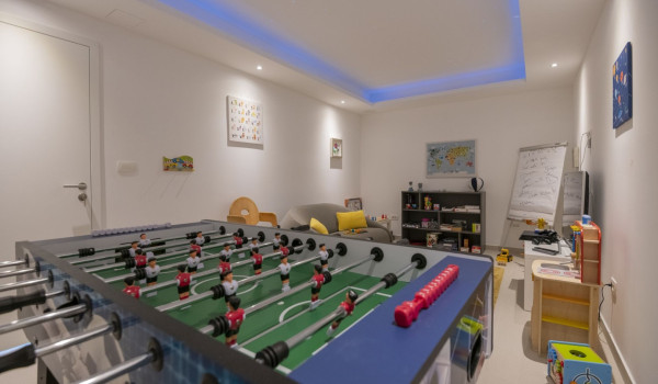A table for table football, a comfortable sofa and an LCD TV in the room in the luxury villa for rent and vacation Glorious Brela in Brela