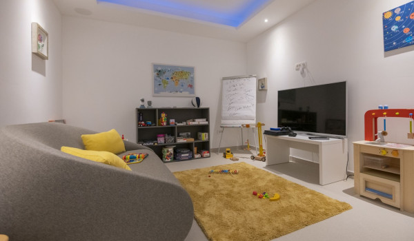 A room with children's facilities, a shelf with toys, a sofa and a playstation in the luxurious villa by the sea Glorious Brela in Brela
