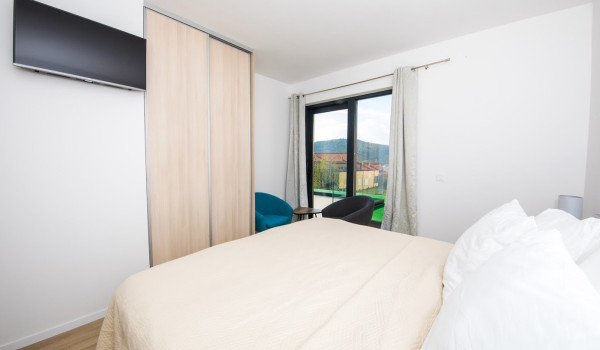 Bedroom with double bed, LCD TV, armchairs and access to the balcony in the luxury villa Mlini Quiet Land near Dubrovnik with concierge service and parking