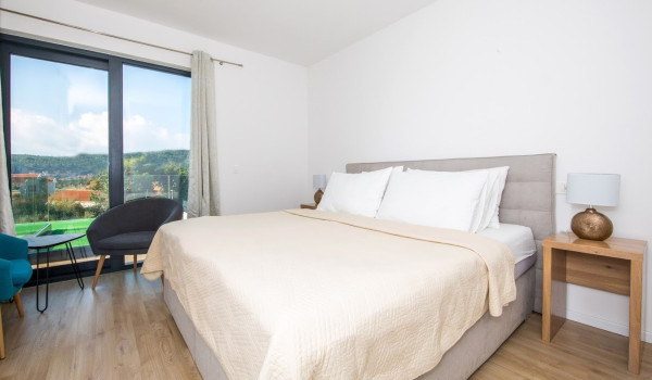 Bedroom with double bed,  armchairs and access to the balcony in the luxury villa Mlini Quiet Land near Dubrovnik with concierge service and parking