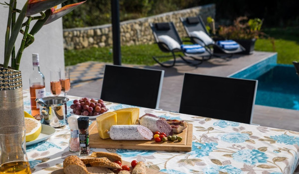 Traditional breakfast on the outdoor dining table in the Croatia luxury villa for family vacation near Dubrovnik