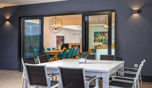 Outdoor and indoor dining table for eight people in the luxury villa Quiet Land with private pool and badminton court